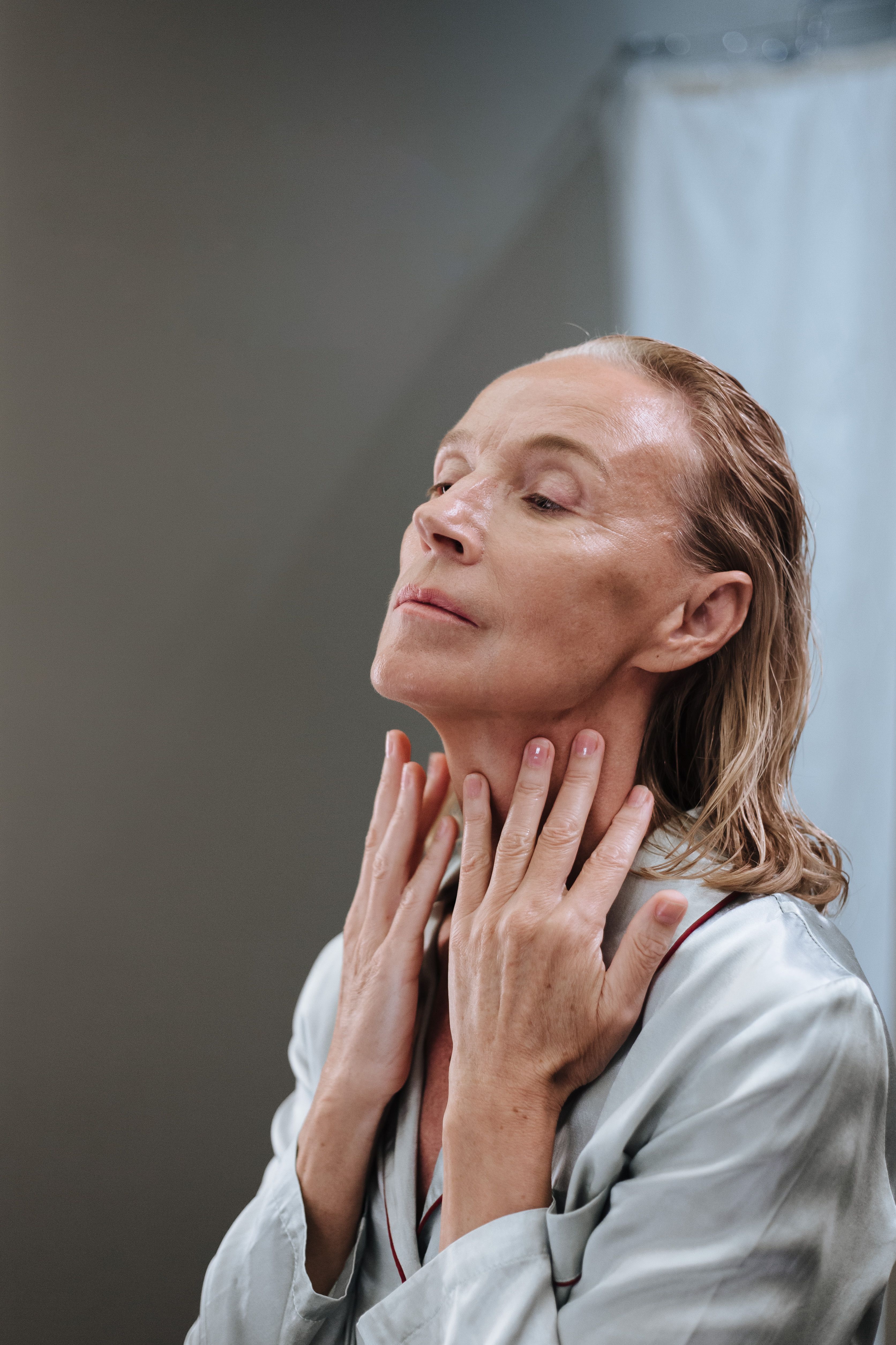 A woman appearing to massage her neck | Source: Pexels