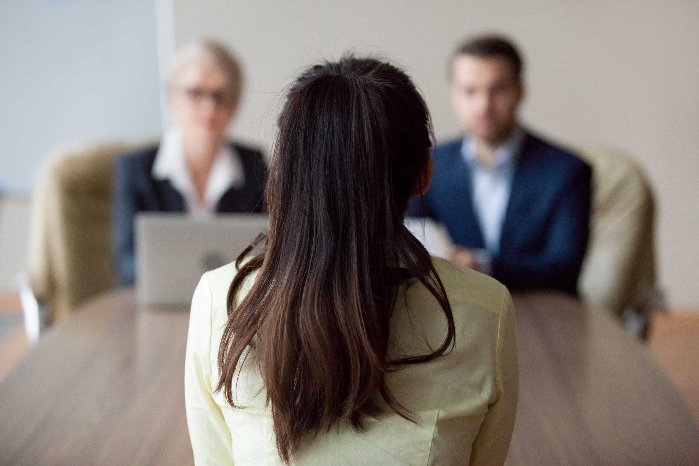A woman sitting with her back to the camera during an interview. | Source: Getty Images