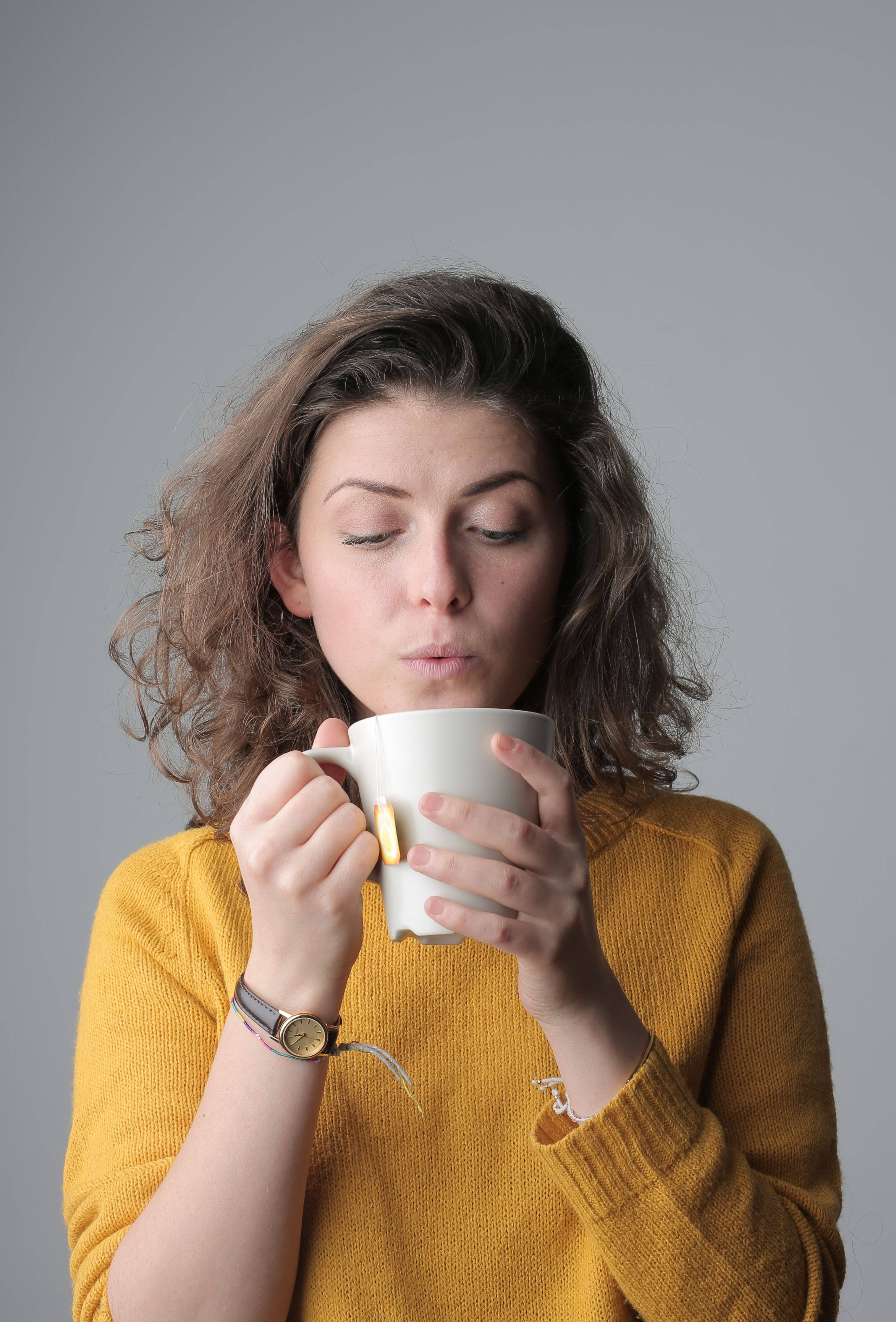 A woman blowing on her tea | Source: Pexels