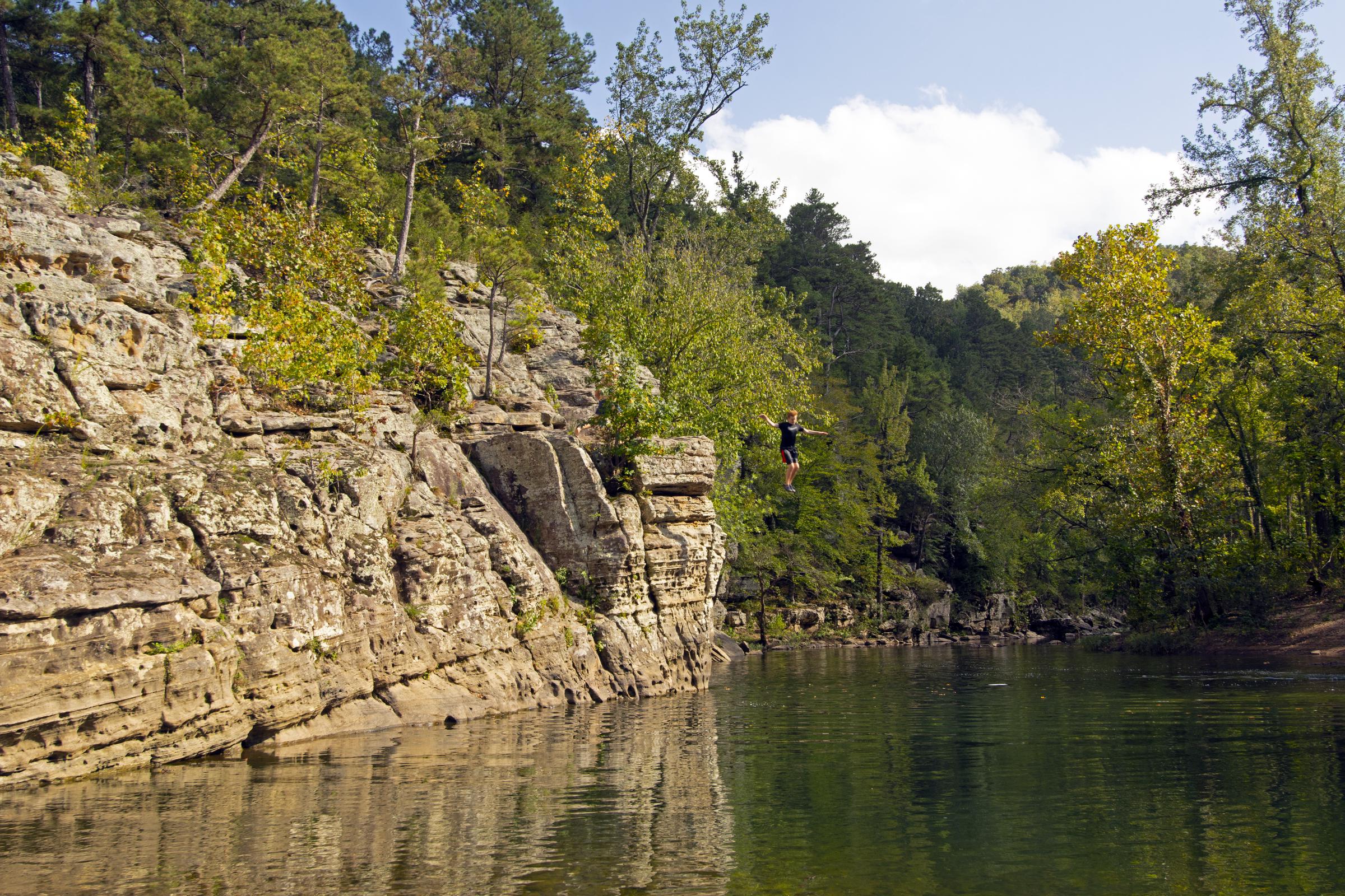 Boy jumps in the Buffalo River at the Ozark National Forest Park in Arkansas | Source: Getty Images