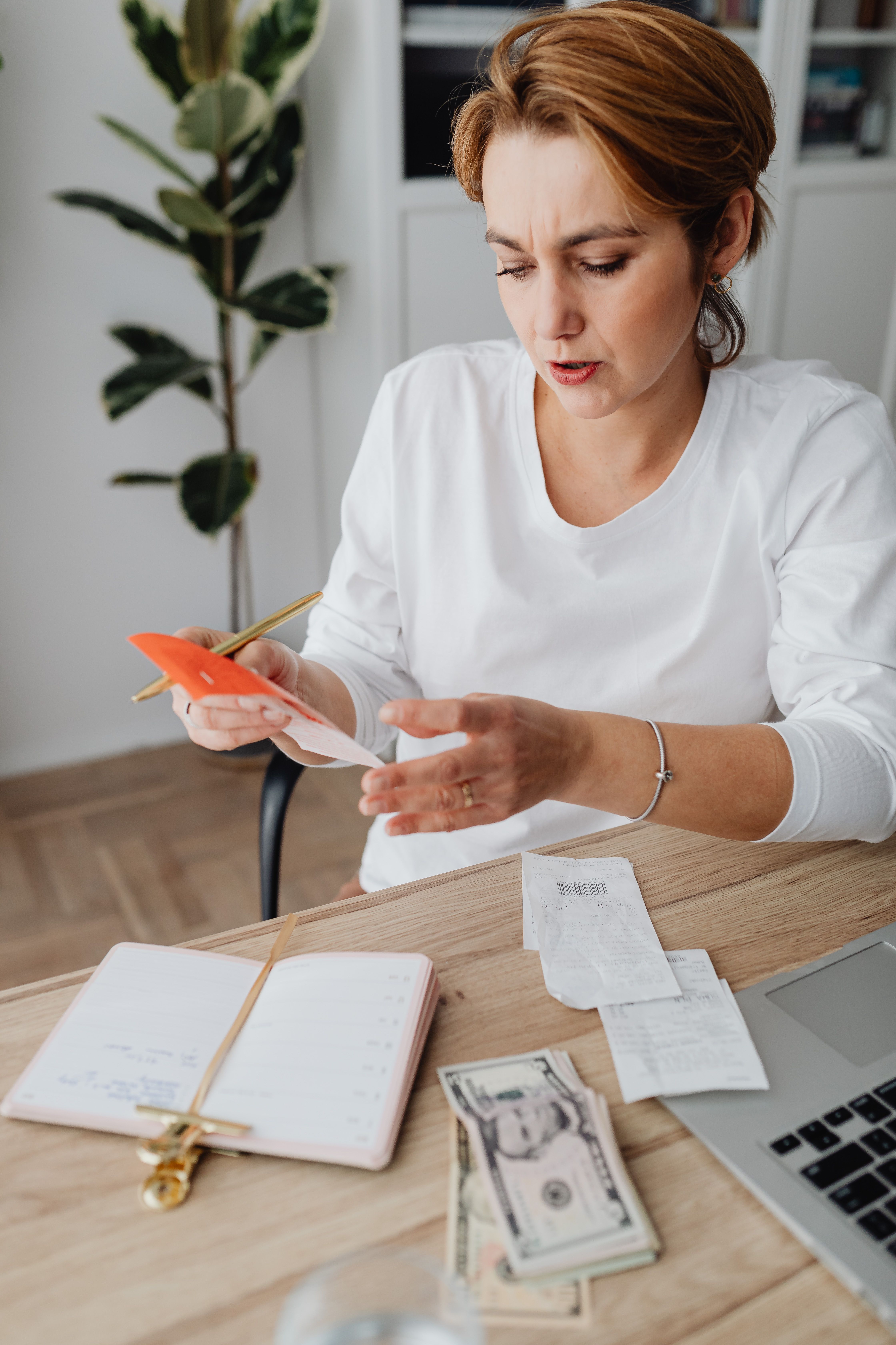A woman calculating expenses with a notebook and calculator | Source: Pexels