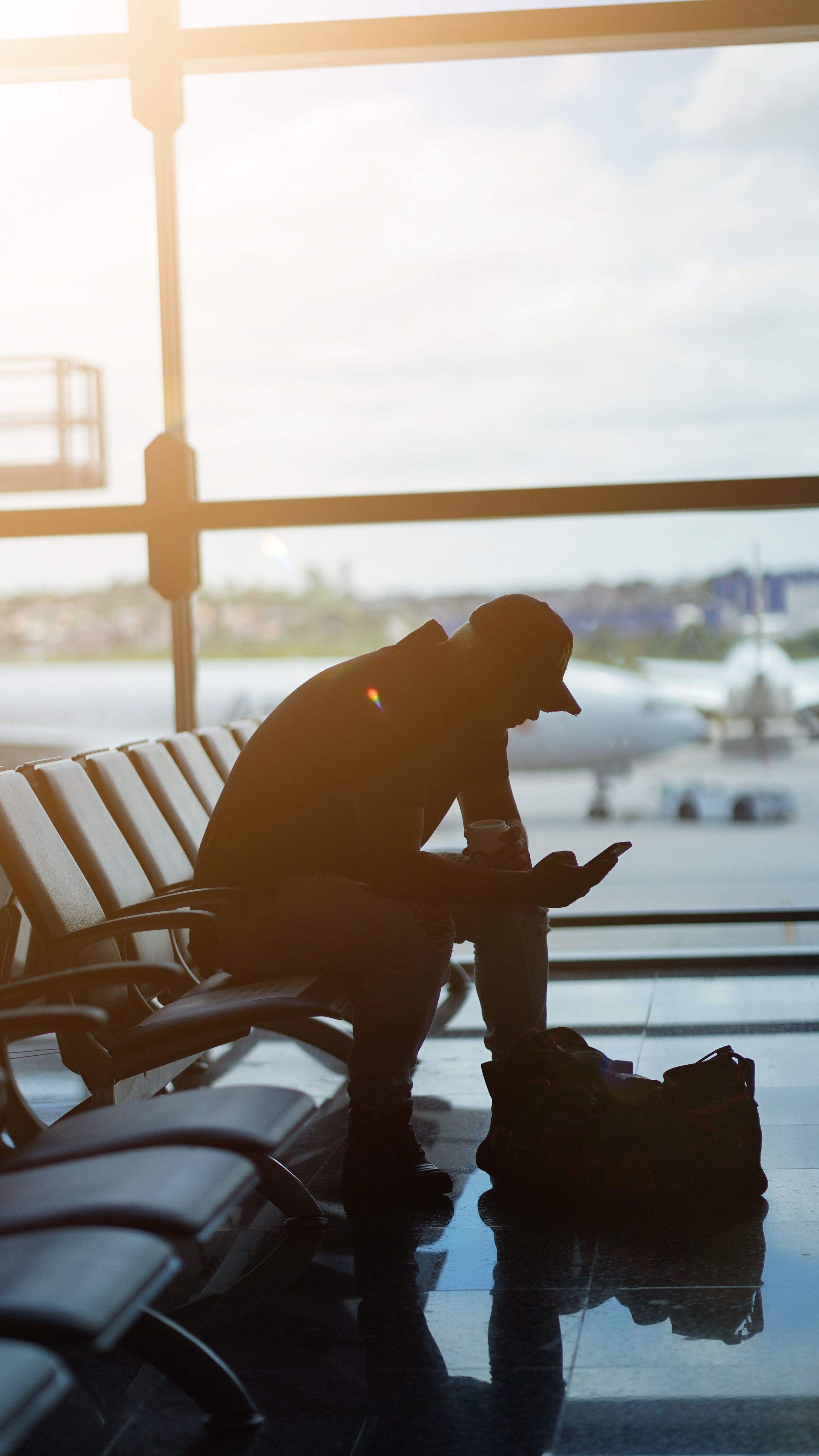 Silhouette of a man at seated alone at an airport's boarding area | Source: Pexels
