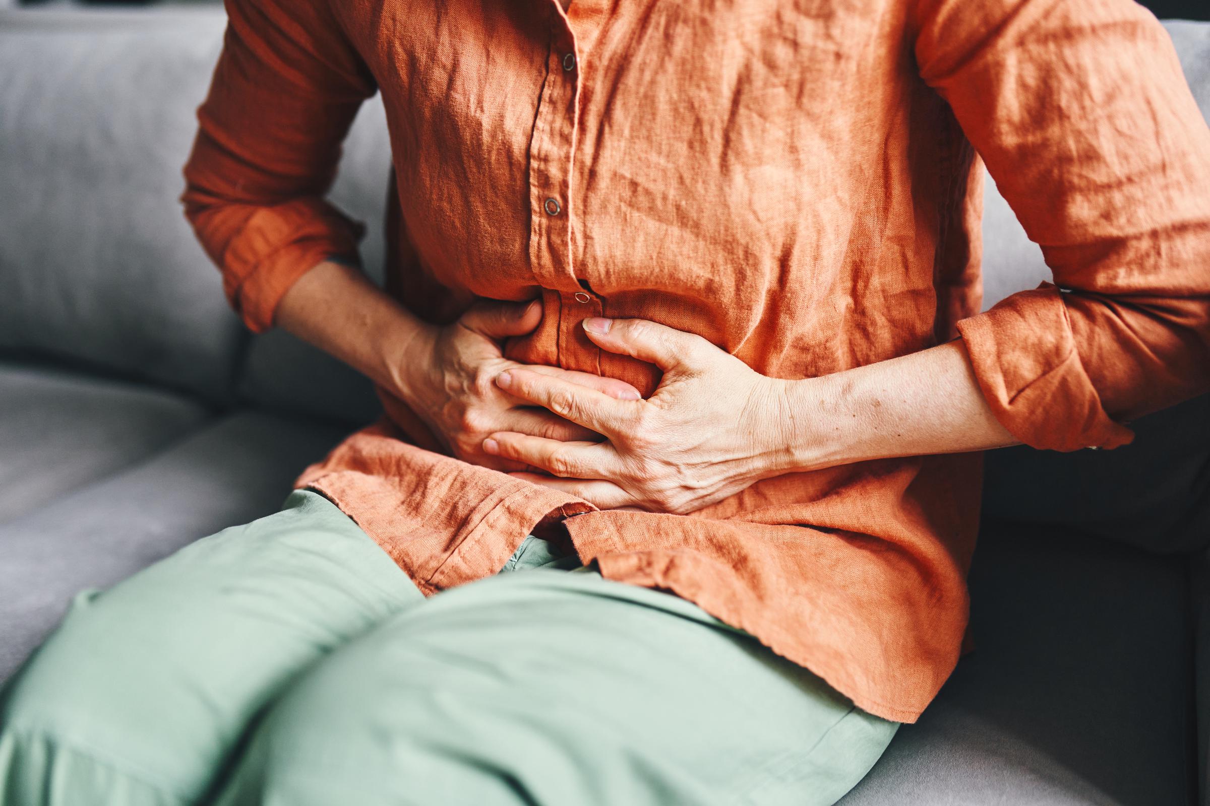 A woman holding her stomach in pain | Source: Getty Images