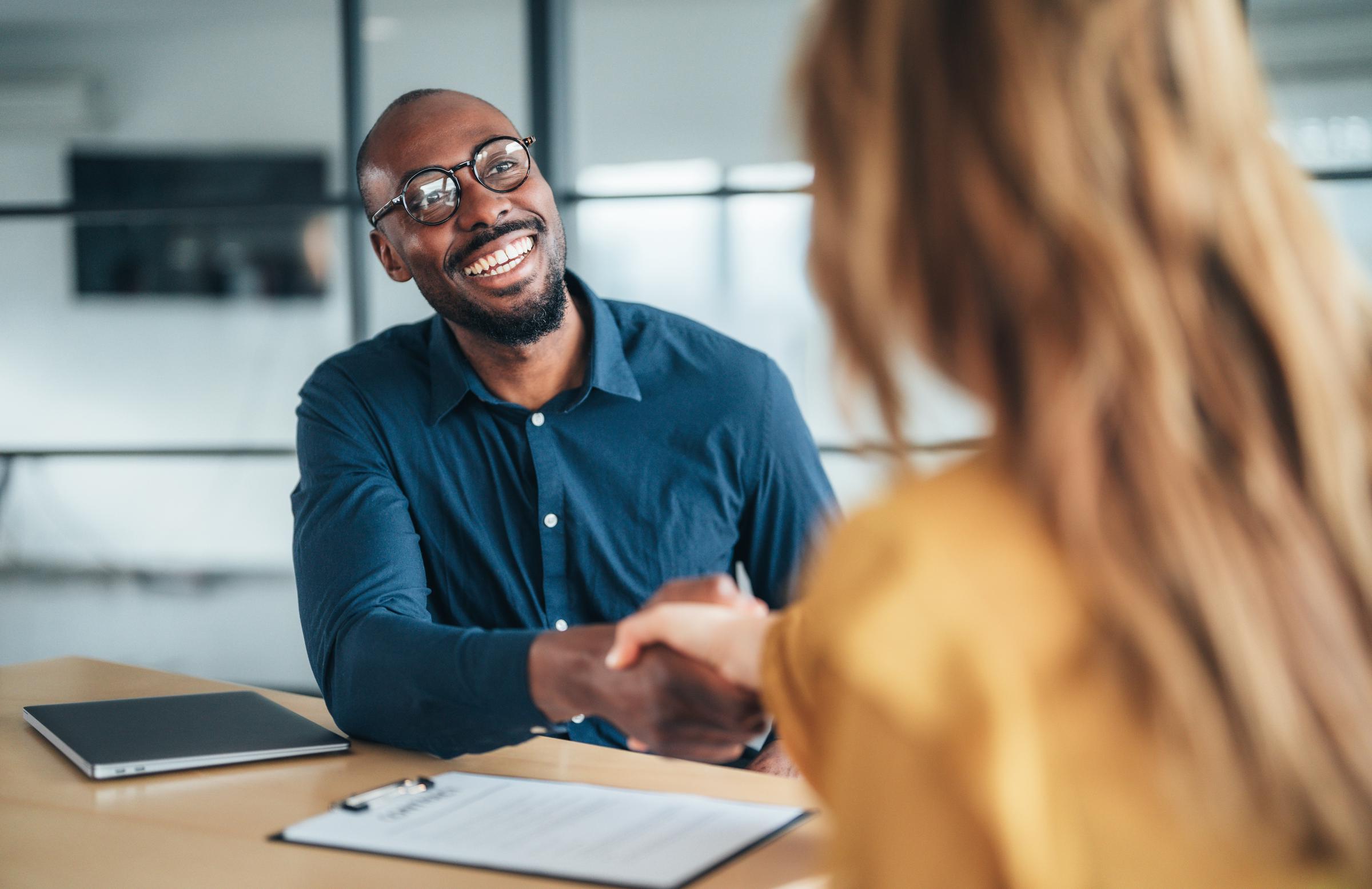 A job candidate shaking a hiring manager's hand | Source: Getty Images