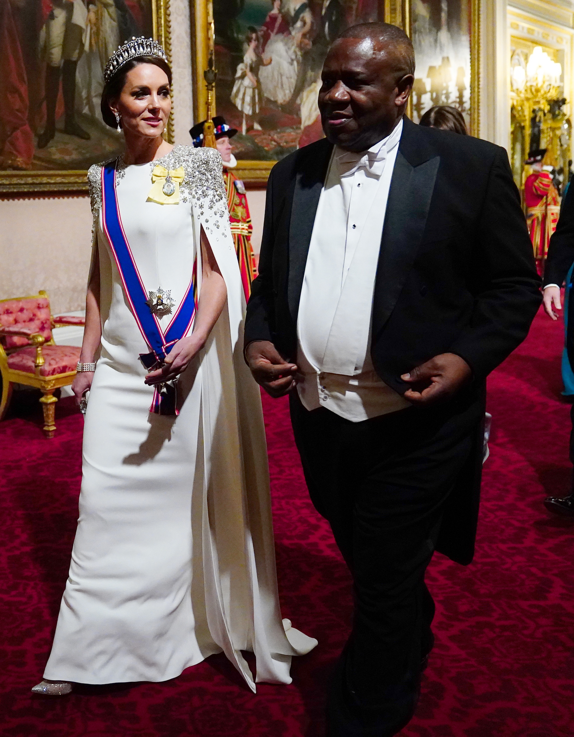Catherine, Princess of Wales, arrives for the State Banquet honoring South African President Cyril Ramaphosa at Buckingham Palace on November 22, 2022, marking her first banquet appearance in the role. She wears an ivory Jenny Packham cape gown with crystal-embellished shoulders, accessorized with Queen Mary's Lover's Knot Tiara, Princess Diana's pearl earrings, and royal honours. | Source: Getty Images