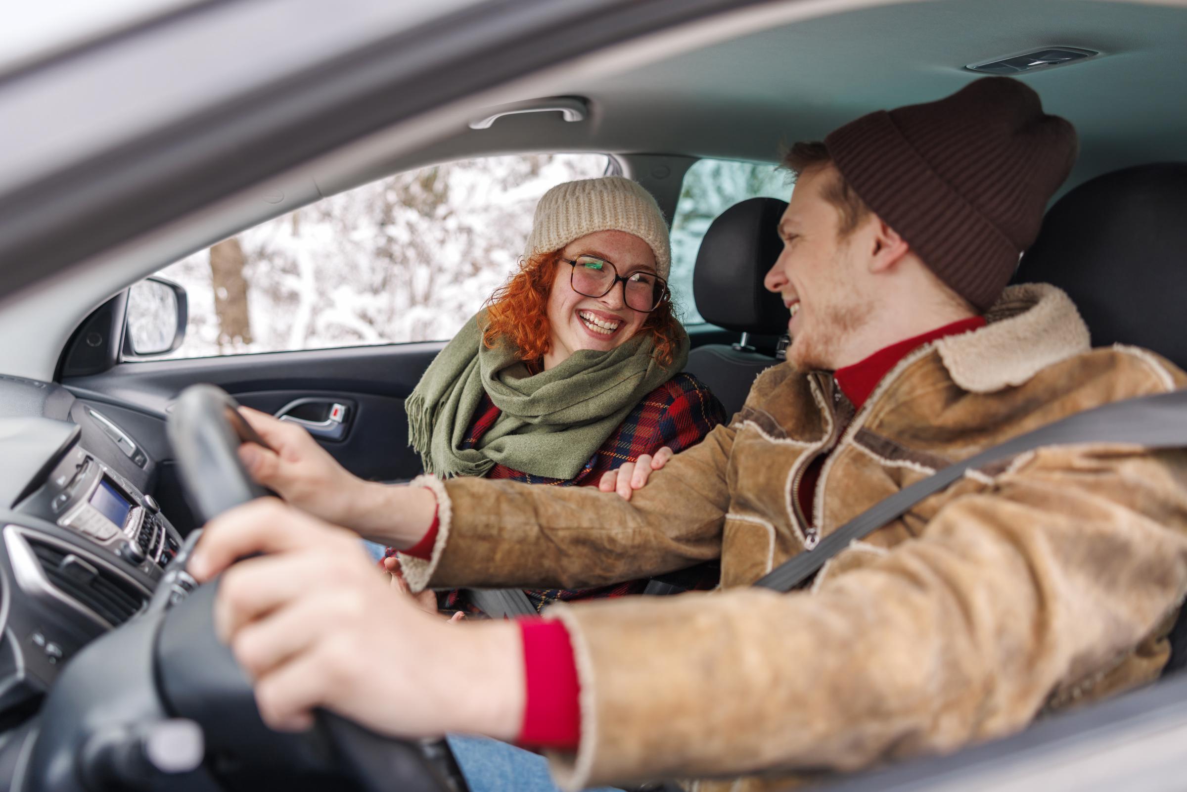 A young couple driving to a winter vacation | Source: Getty Images