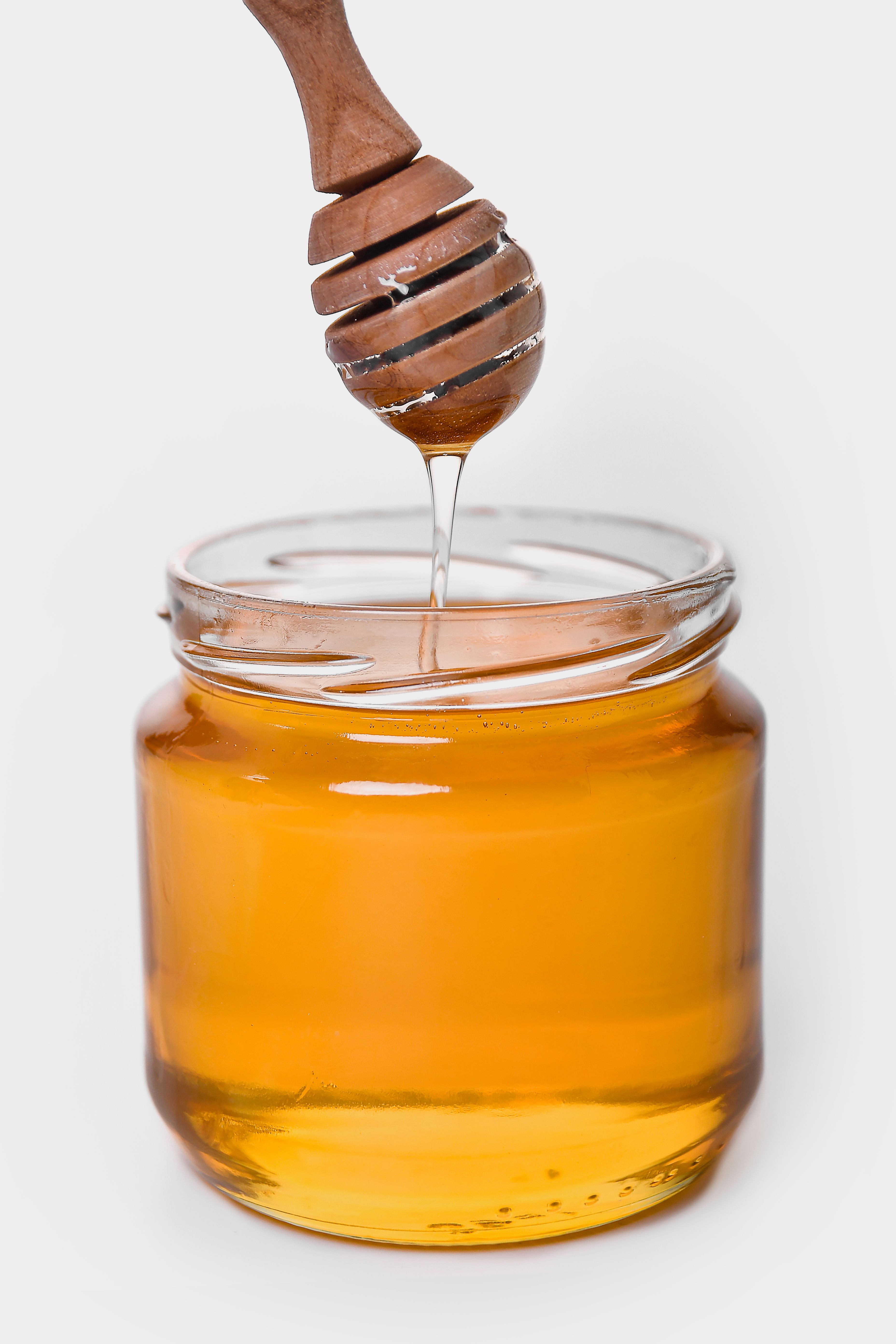 A wooden dripper and a jar of honey | Source: Pexels