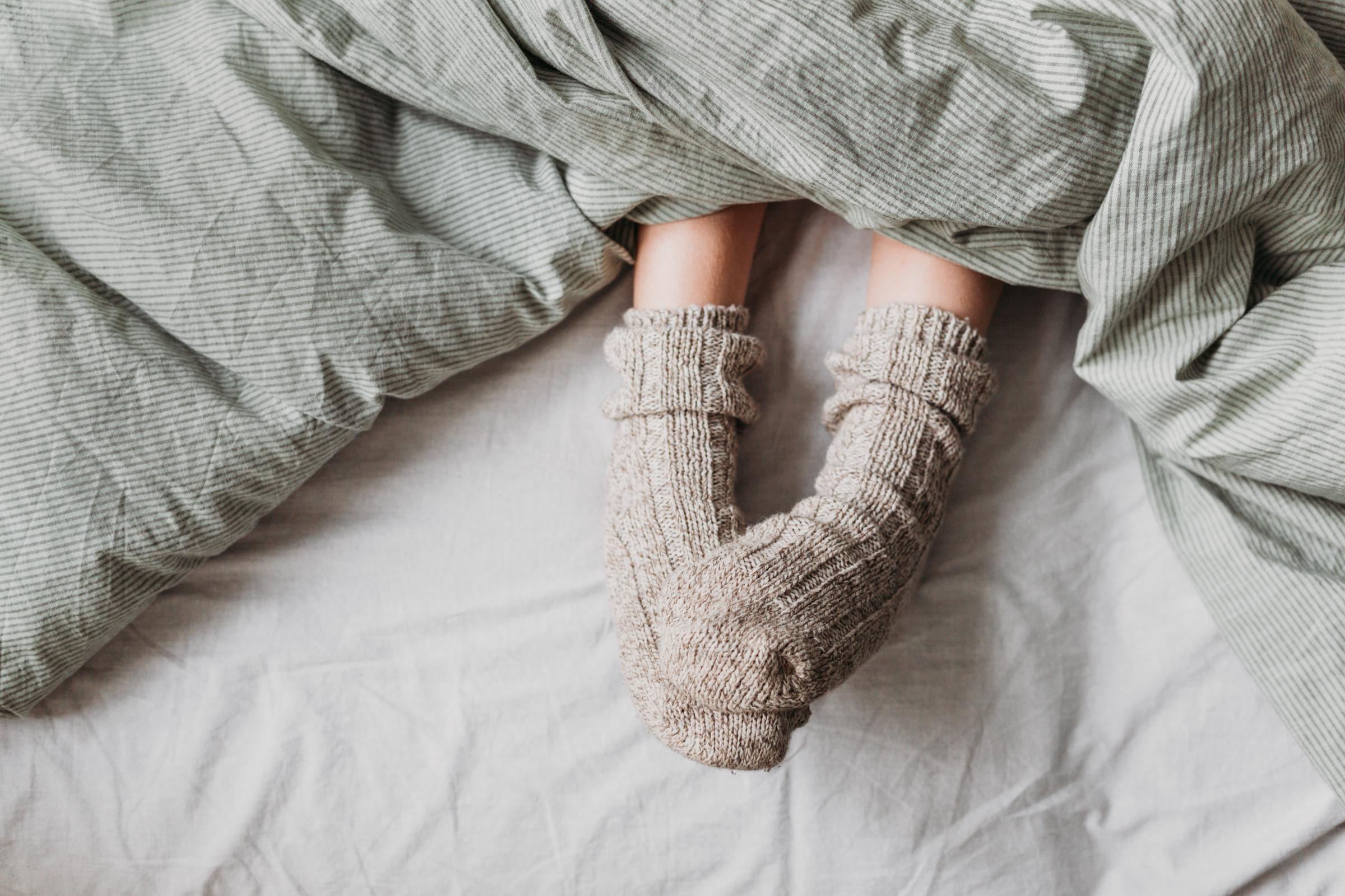 A child wearing warm wool socks in bed | Source: Getty Images