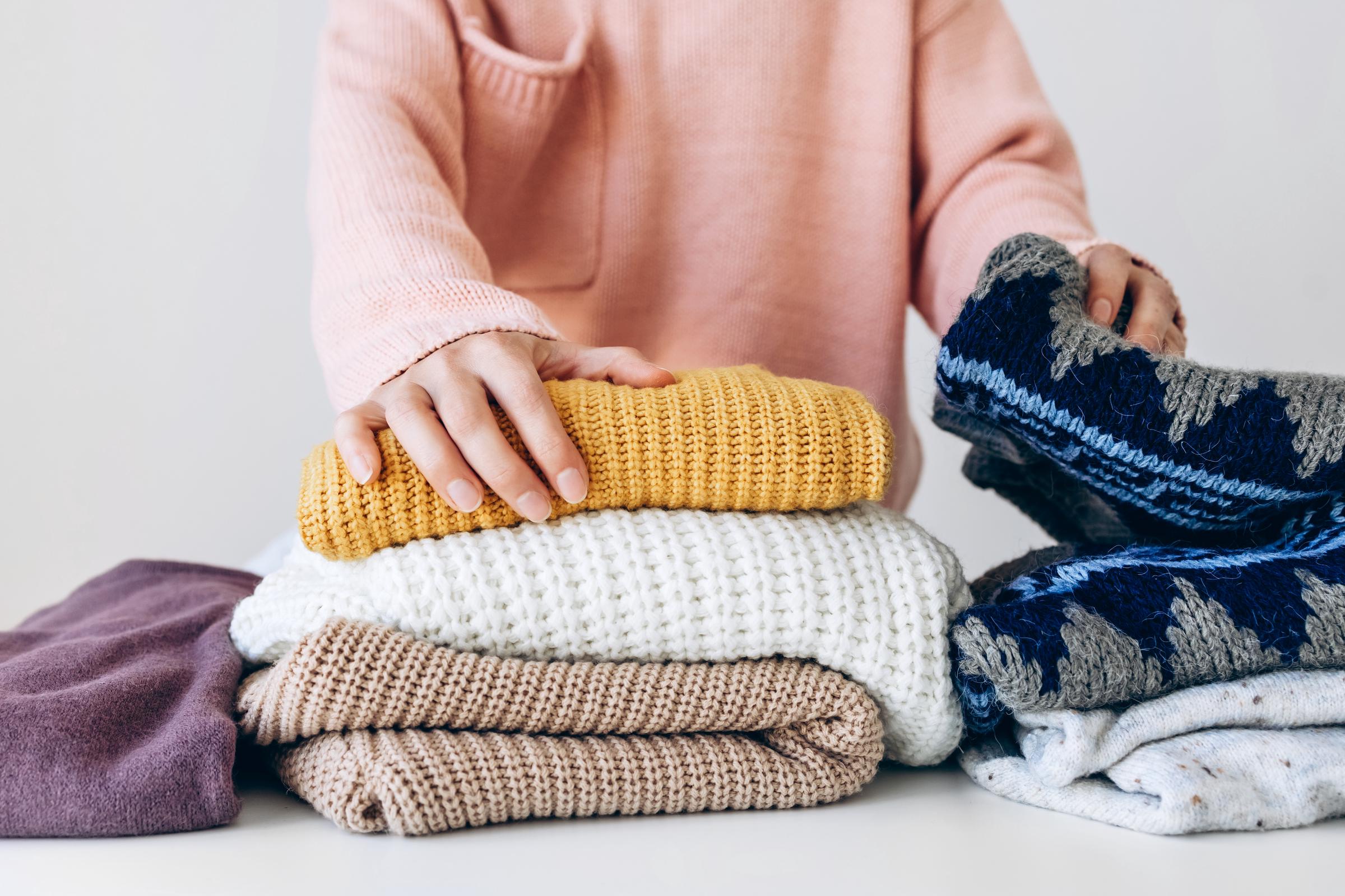 A woman organizes her sweaters at home | Source: Getty Images