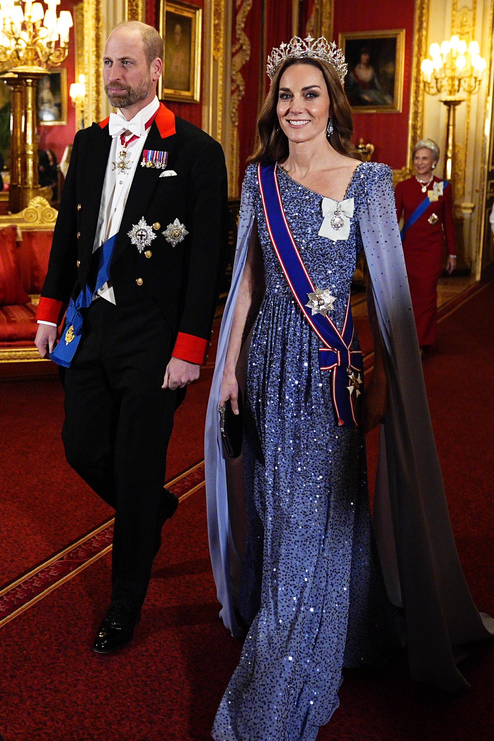 Prince William and Catherine, Princess of Wales, arrive for the state banquet honoring German President Frank-Walter Steinmeier and his wife, Elke Büdenbender, at Windsor Castle on December 3, 2025. Catherine glitters in a shimmering periwinkle-blue sequined Jenny Packham gown featuring a floor-sweeping split cape, accessorized with the Queen Mother's Strathmore Rose Tiara, the Royal Victorian Order sash, and King Charles III's Royal Family Order, while William wears formal Windsor tailcoat attire with ceremonial honors. | Source: Getty Images