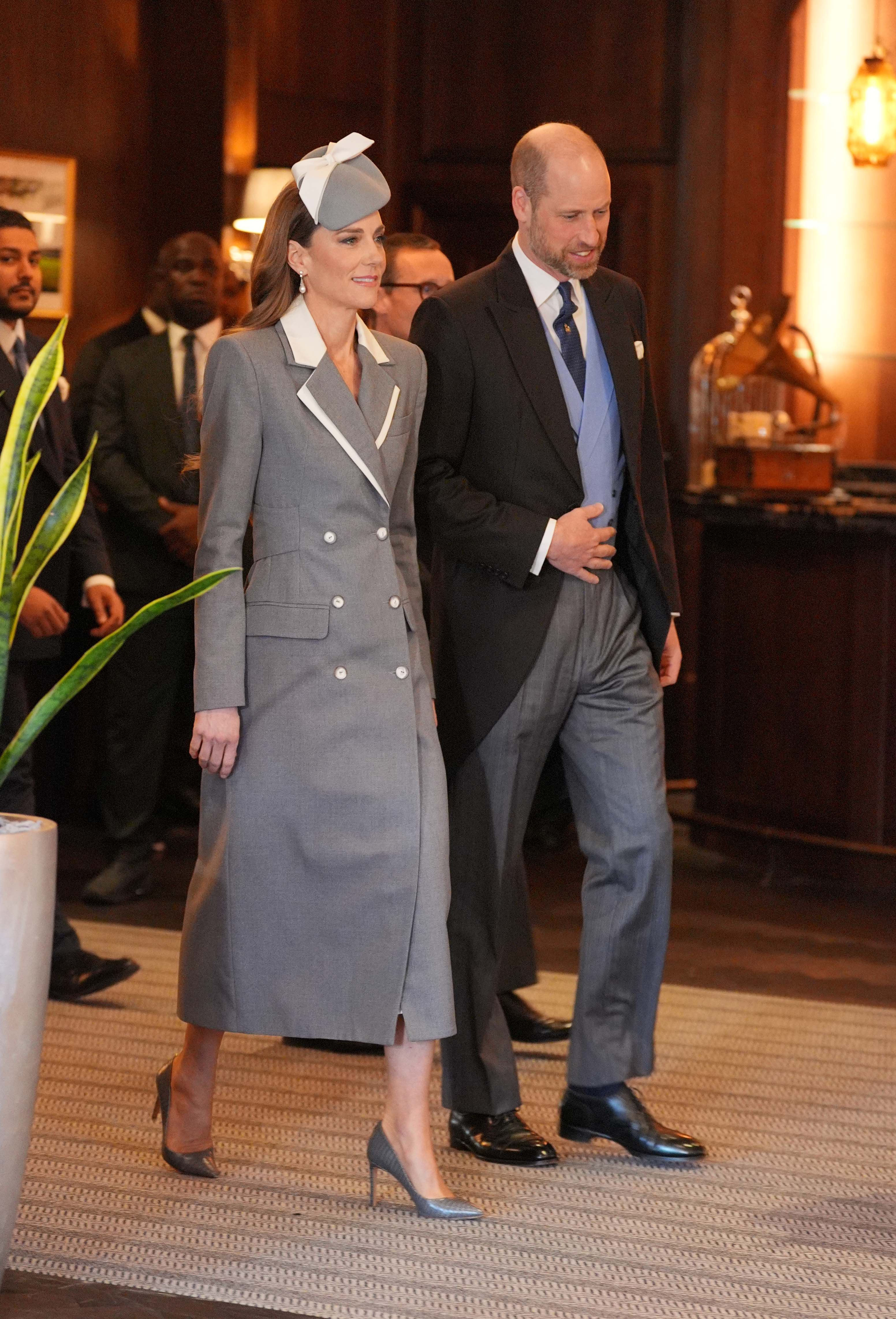 Catherine, Princess of Wales, arrives alongside Prince William to receive President Bola Ahmed Tinubu and First Lady Oluremi Tinubu of Nigeria at the Fairmont Windsor Park hotel on March 18, 2026, marking the start of the Nigerian State Visit. Dressed for the occasion, Catherine wears a tailored grey double-breasted coatdress with white lapels and buttons, paired with a matching bow-accented pillbox hat and grey pumps. | Source: Getty Images