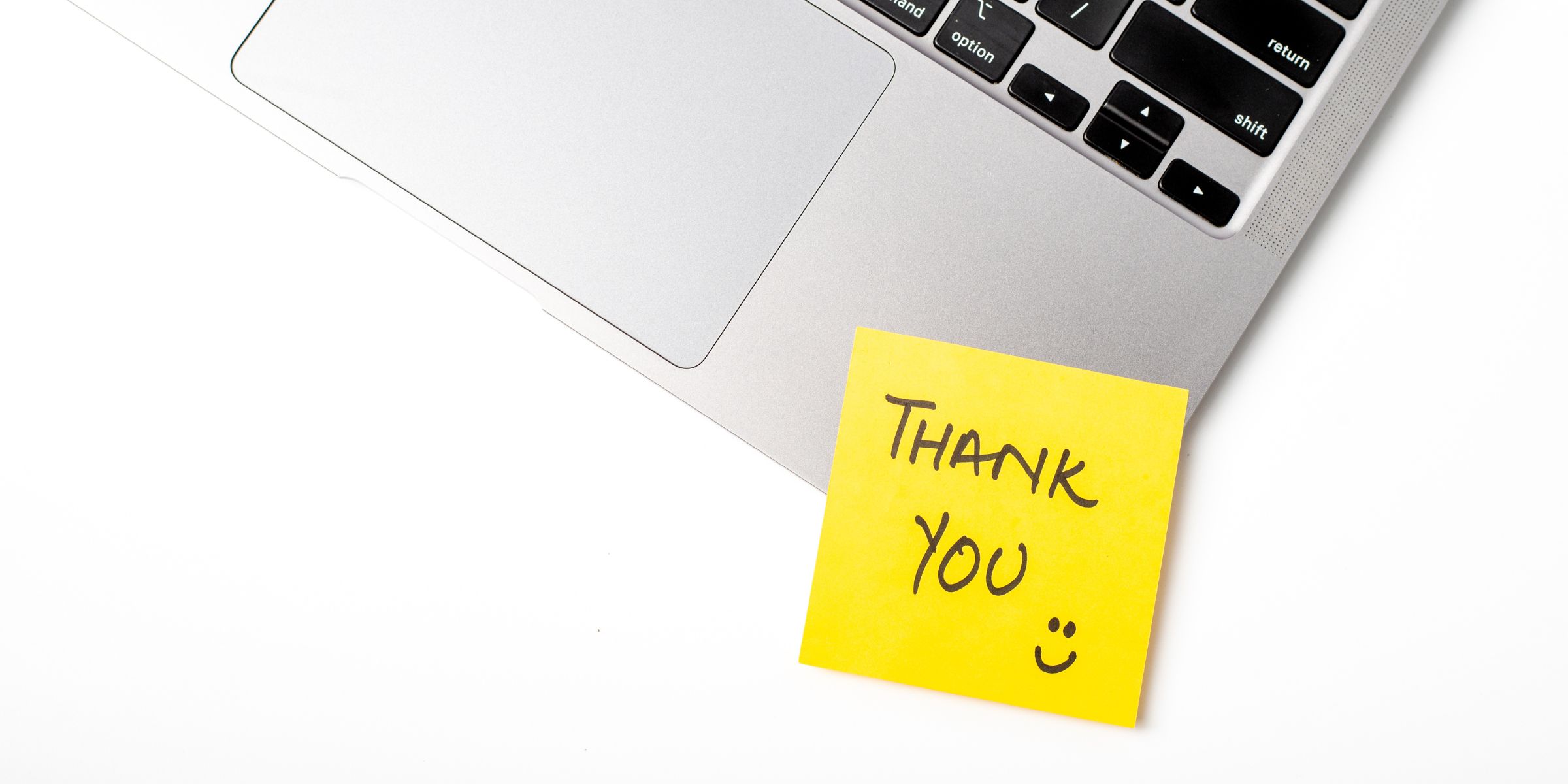 A thank-you note taped to a laptop | Source: Getty Images